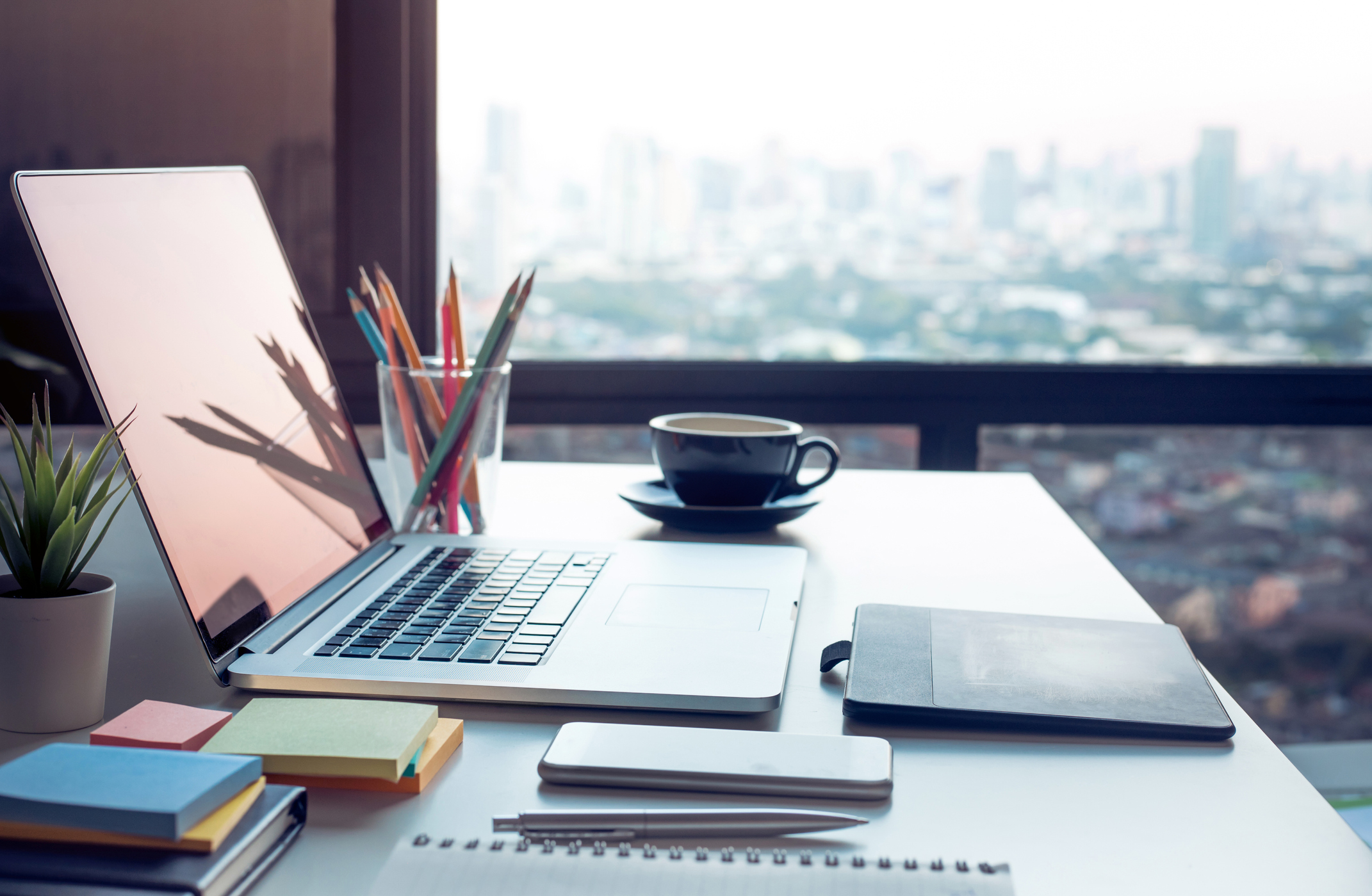 Modern work table with computer laptop and cityscapes viewfrom window.Business concepts ideas